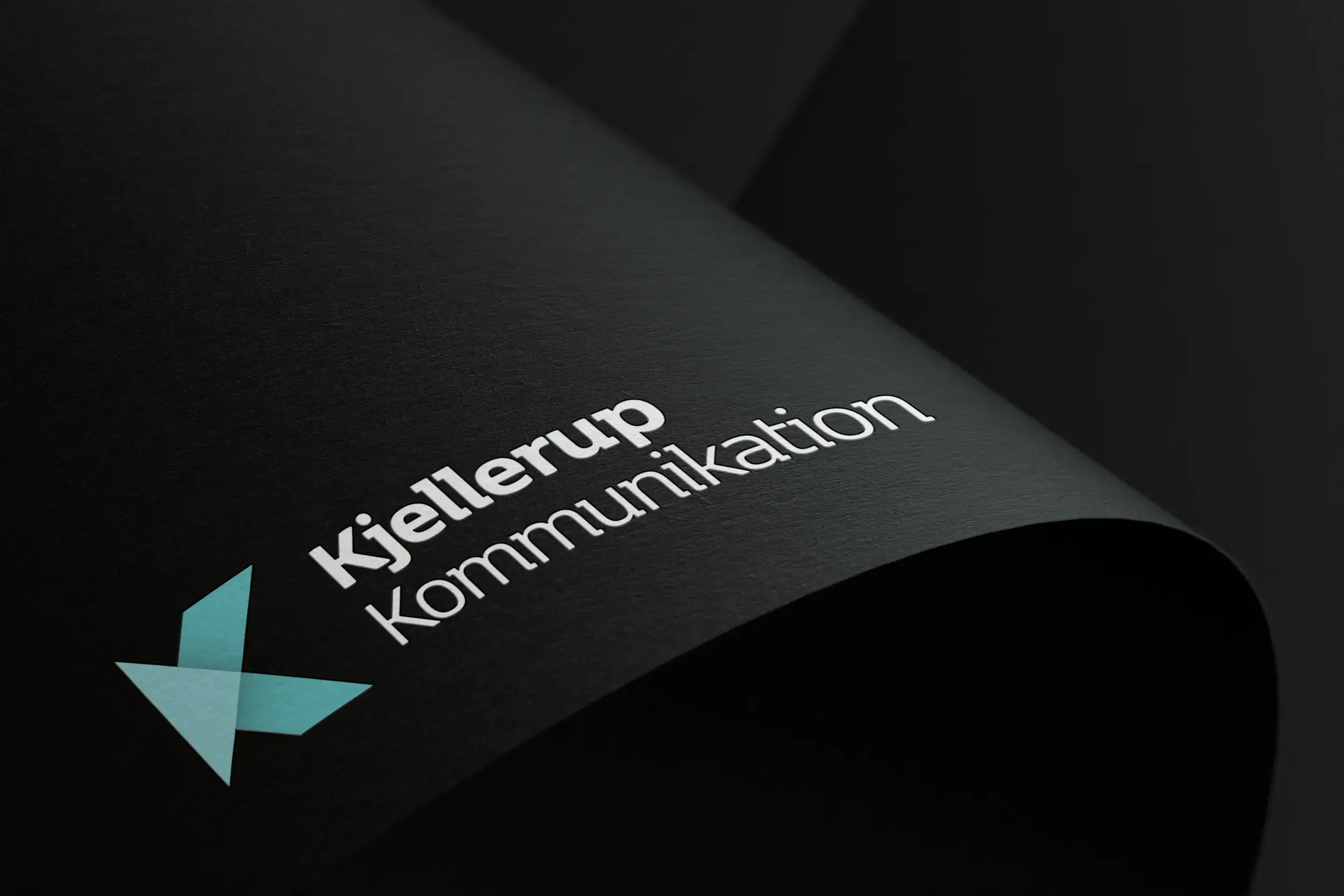 Kjellerup kommunikation logo på sort papir